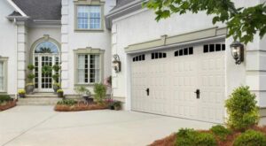 white traditional garage doors with windows and handles